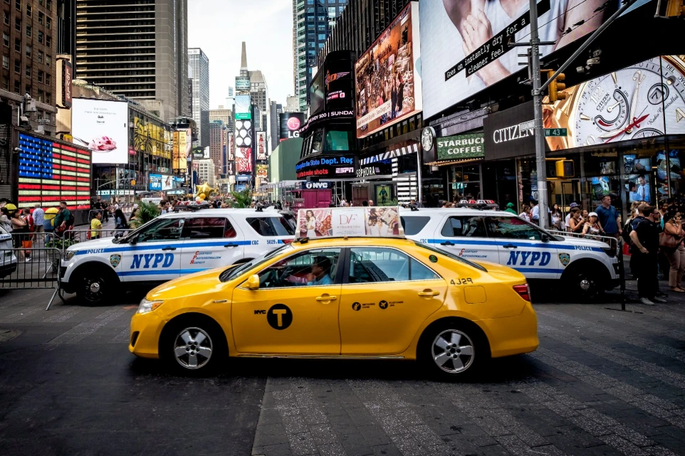 yellow sedan beside police cars